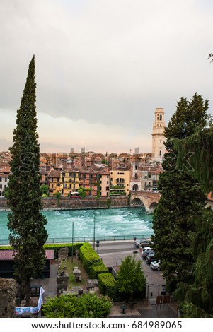 Panoramic view to City of Verona with river at sunny day at sunset. Veneto region, Italy. Sunny summer day panorama, sky with clouds and famous european italian terracotta color houses, bird view
