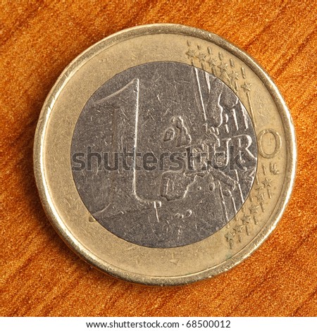 euro coin on wooden surface