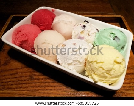 Variety of Ice cream scoops in a bowl, Close up of Multi-color ice cream on wood table. Top view, selective focus. 