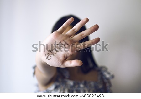 Young lady showing hand with "enough" writing on it as a sign to stop violence Royalty-Free Stock Photo #685023493