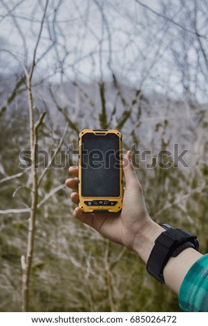 smartphone shockproof in forest background. girl journey in woodland