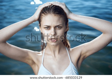 Woman straightening wet hair sea                               