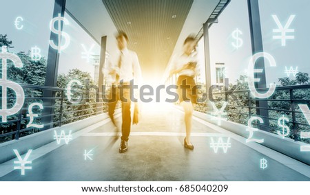 Businessman and businesswoman walk confidently on the corridor between buildings. Motion action. Low speed shutter. with many currency symbols floating in the air.