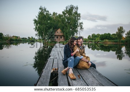 Cute young and happy couple on river background