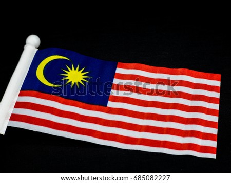 Malaysia flag also known as Jalur Gemilang wave isolated over dark background. Conceptual photo for the Independence Day Celebration or Merdeka Day, 31 of August.