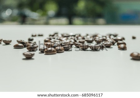 Close up of coffee beans placed on a white table 