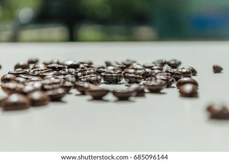 Close up of coffee beans placed on a white table 
