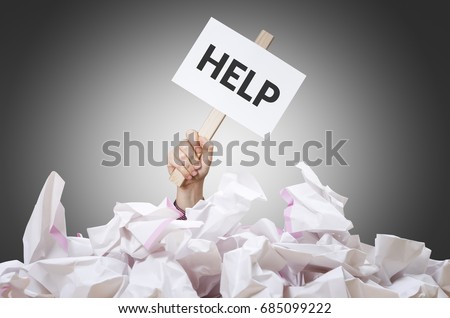 Help placard in hand with crumpled paper pile.  Royalty-Free Stock Photo #685099222