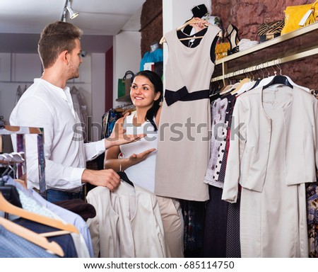 Happy pleasant family choosing dress and blouse at clothing shop