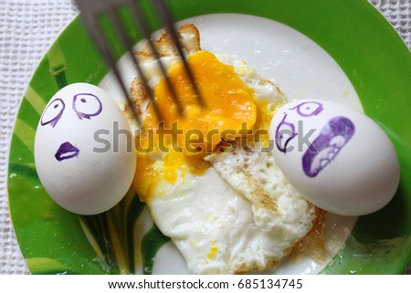 Eggs with painted face. Photo for your design. Eggs float in a plate. Four eggs.