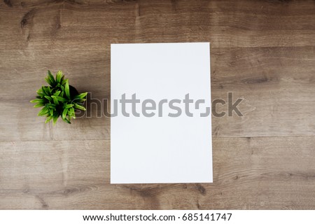 White template paper and flower on wooden background