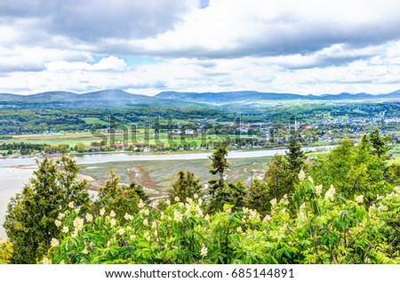 Baie-Saint-Paul in Quebec, Canada cityscape or skyline with buildings, mountains on coast and Saint Lawrence river