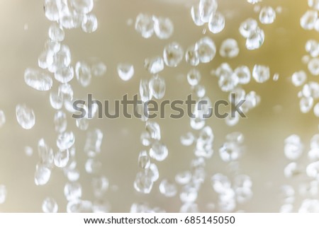 Abstract bokeh background of blurry water drops against yellow background macro closeup