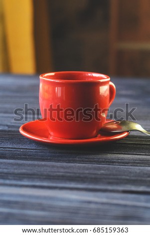 A cup of red espresso on a wooden table in the cozy interior of a cafe