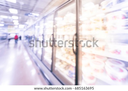 Blurred frozen food section at retail store in US. Huge glass door aisle with variety pack of processed fruit, vegetable, breakfast, appetizer, side, meals, pizza. Customer shopping. Vintage tone.