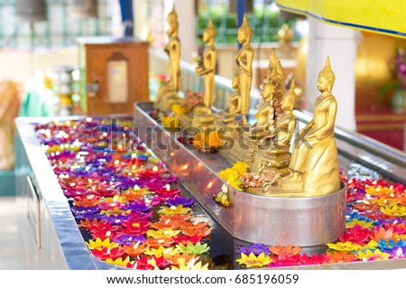 Lotus multicolored candles floating in water surrounding the Buddha statue.The temple is a of religious importance and public place for general people either Thai and foreign visitors.