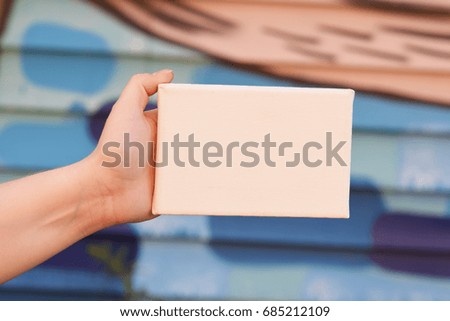 Hand Holding a Tiny Canvas
