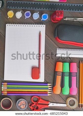 flat lay school tools on a desk. with colorful pencils, markers, paints, ruler, scissors, sharpener, eraser, duct tape. top view from above