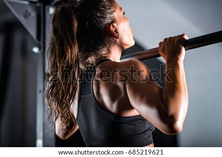 Woman athlete doing pull ups Royalty-Free Stock Photo #685219621