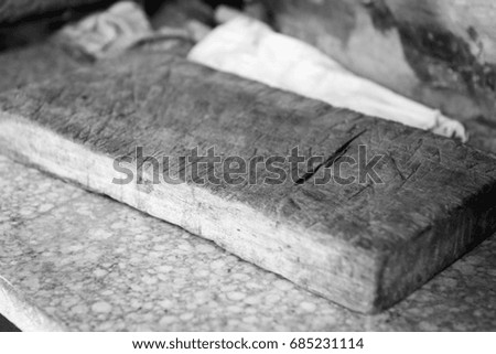 Old vintage chopping board in outdoor kitchen with very shallow focus in black and white