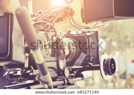 Cameraman with his video camera shooting, Hands Adjusting Camera,film production crew, behind the scenes background.