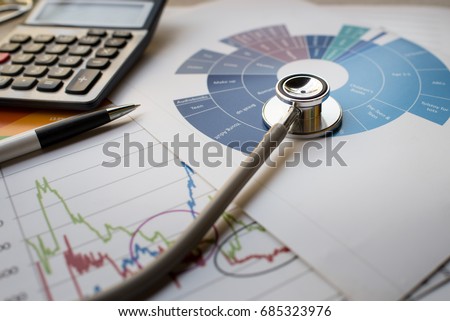 Medical practice financial analysis charts with stethoscope and calculator concept Royalty-Free Stock Photo #685323976