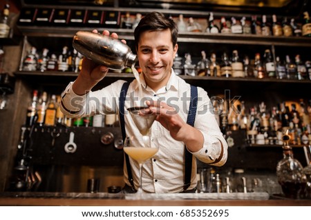 smiling bartender with fancy cocktail and shaker Royalty-Free Stock Photo #685352695