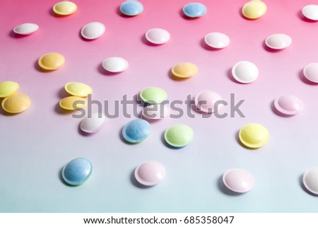 flying saucer multicolored candy sweets on a gradient background pink and blue.
Minimal color still life photography
