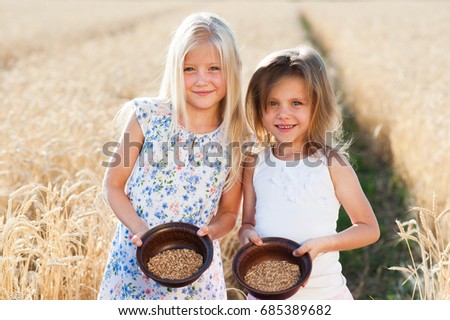 Two beautiful girls in a field of wheat