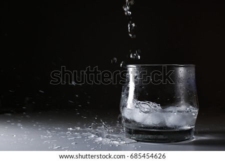 Water is poured into a glass and have splash water out of glass.