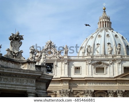 View of dome, clock and statues at the top of St. Peter's Basilica, Vatican City, Rome, Italy.