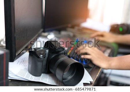 Photographer editing and retouch photos with camera, double screen at home 