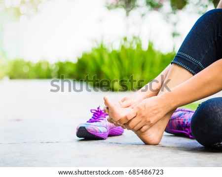 Young woman massaging her painful foot from exercising and running Sport  and excercise concept. Royalty-Free Stock Photo #685486723