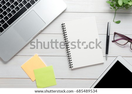 business workplace with laptop, gadgets and empty notebook on wooden table
