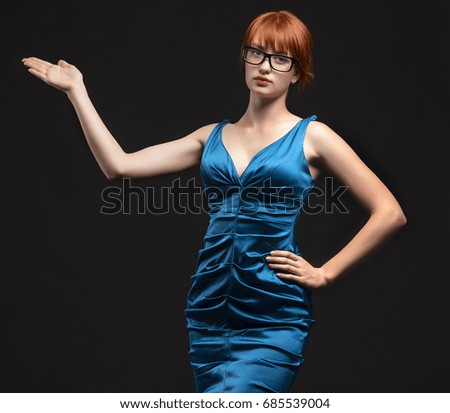 Young confident woman showing by hands on a black background. Ideal for banners, registration forms, presentation, landings, presenting concept.