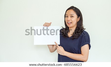 Casual beautiful Asian woman holding white sign with copy space