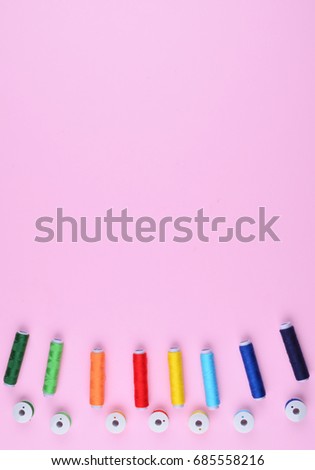 Background with stylish sewing tools and accessories on trendy pink background.