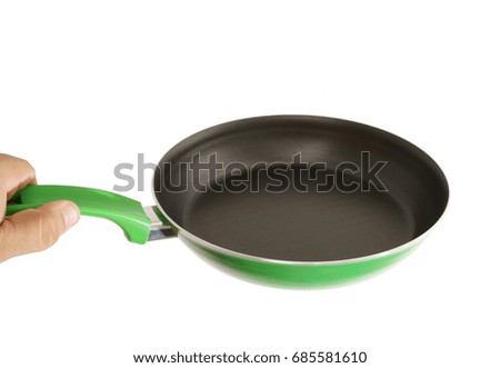man's hand holding a frying empty green pan isolated on white background. food object and empty background