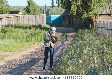 Girl teenager photographer using a digital camera in rural countryside