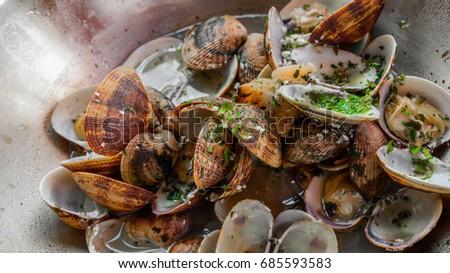 Seafood. Close up shells venus steamed clams with parsley, garlic and herbs in wok 
