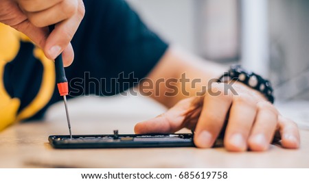 Technician repair faulty mobile phone in electronic smart phone technology service. Cellphone technology device maintenance engineer Royalty-Free Stock Photo #685619758