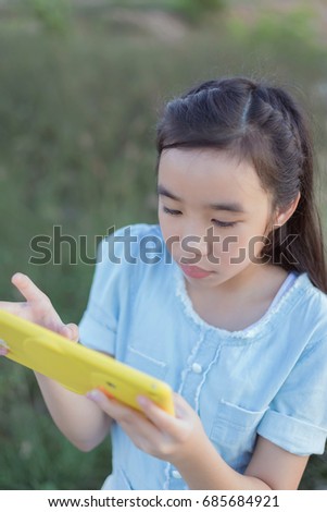 asian girl use tablet pc at park.