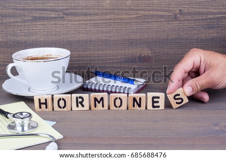 hormones. Wooden letters on dark background Royalty-Free Stock Photo #685688476