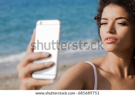 Young woman portrait taking selfie at the beach