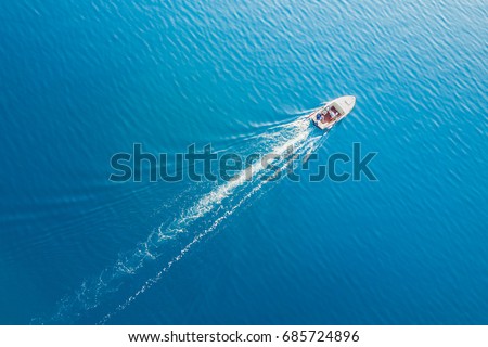 Top view of a white boat sailing in the blue sea Royalty-Free Stock Photo #685724896