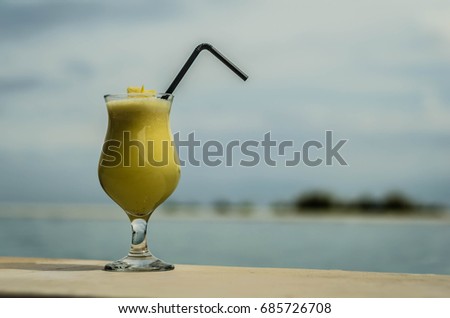 Cold and fresh glass jar with cold water near the pool and a sea view on a horizon

