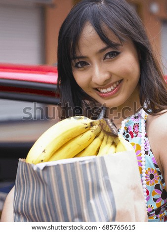 Woman carrying grocery bags, smiling