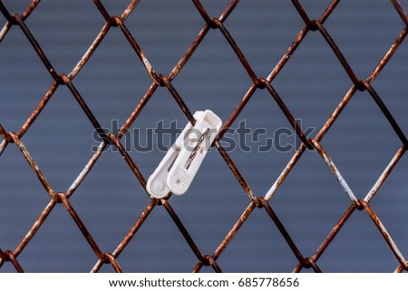 Clothes clip Clamped on the old wire mesh fence rust
