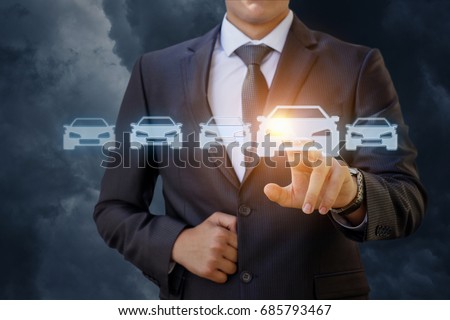 The businessman selects a car on a blue background. Royalty-Free Stock Photo #685793467