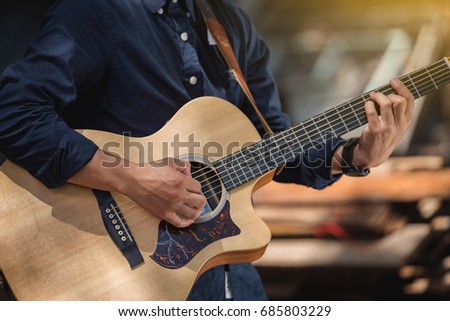 Detail of a man playing guitar,musician playing acoustic guitar,concept for live music festival.